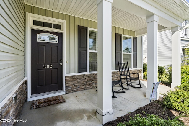 202 Bungalow Rd, Holly Ridge, NC 28445 - entrance to property featuring a porch, stone siding, and board and batten siding