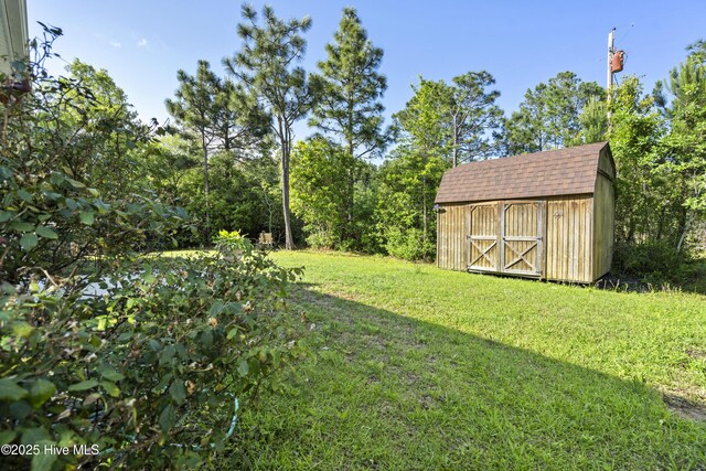202 Bungalow Rd, Holly Ridge, NC 28445 - view of grassy yard with a storage unit and an outbuilding