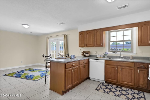 805 Hamlet Ave, Carolina Beach, NC 28428 - kitchen featuring dishwasher, a sink, a peninsula, brown cabinets, and light tile patterned floors