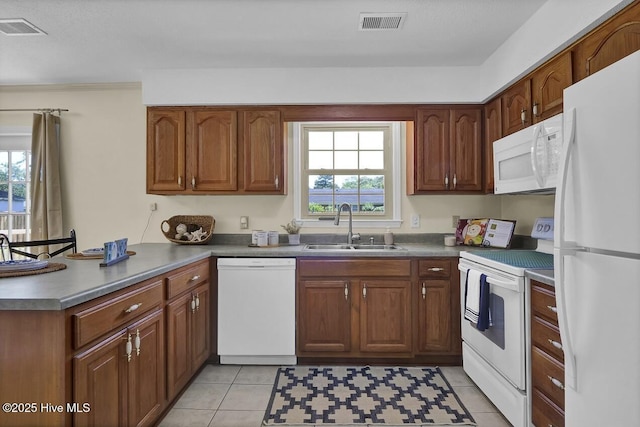 805 Hamlet Ave, Carolina Beach, NC 28428 - kitchen with white appliances, a sink, a peninsula, and brown cabinetry