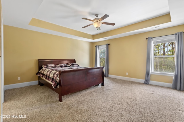 5613 Swiss Stone Ct, Wilmington, NC 28412 - carpeted bedroom featuring a tray ceiling, baseboards, and a ceiling fan