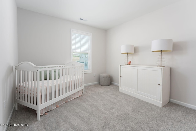 bedroom featuring carpet floors, a crib, and baseboards