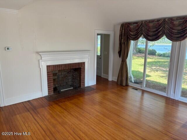 314 Madam Moores Ln, New Bern, NC 28562 - unfurnished living room with wood finished floors, lofted ceiling, and a fireplace