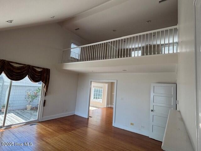 314 Madam Moores Ln, New Bern, NC 28562 - unfurnished living room featuring high vaulted ceiling, wood finished floors, and beam ceiling