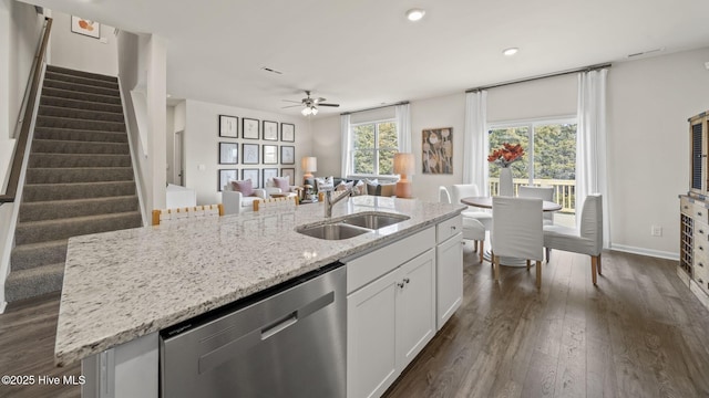 kitchen with stainless steel dishwasher, a sink, an island with sink, white cabinets, and dark wood-style floors