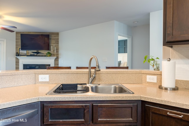 104 Northgate Ln, Clinton, NC 28328 - kitchen with a sink, a ceiling fan, dark brown cabinetry, dishwasher, and a fireplace