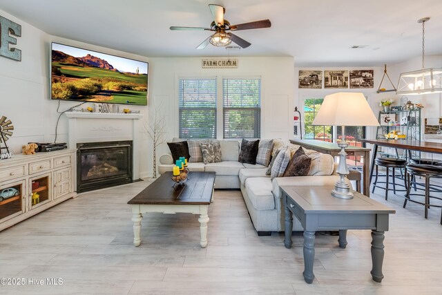 403 Stanford Ct, Maysville, NC 28555 - living room featuring a ceiling fan, a fireplace with flush hearth, and light wood-style floors