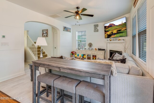 403 Stanford Ct, Maysville, NC 28555 - dining room with a ceiling fan, stairs, arched walkways, light wood finished floors, and baseboards