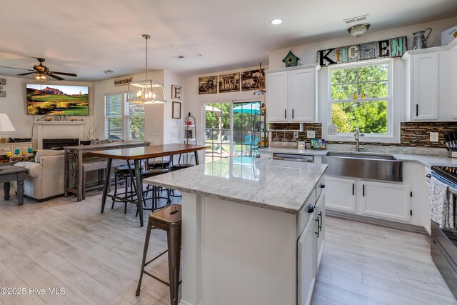 403 Stanford Ct, Maysville, NC 28555 - kitchen with a sink, backsplash, range with electric cooktop, open floor plan, and a center island