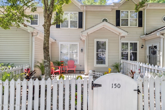 multi unit property with a fenced front yard and a gate