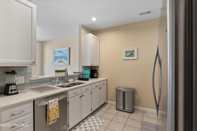 kitchen featuring dishwasher, a sink, refrigerator, white cabinetry, and recessed lighting