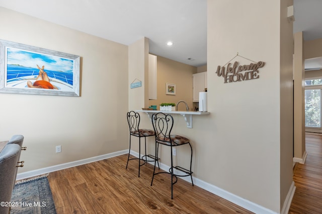 dining area with wood finished floors, baseboards, and recessed lighting