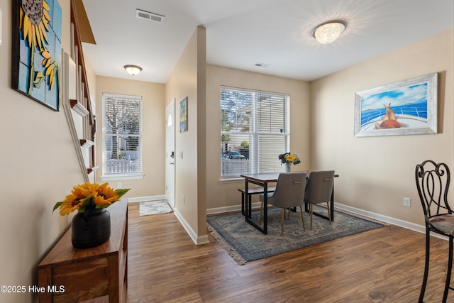 dining room featuring dark wood-style flooring and baseboards
