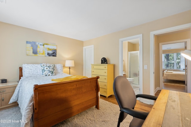 bedroom featuring wood finished floors and ensuite bathroom