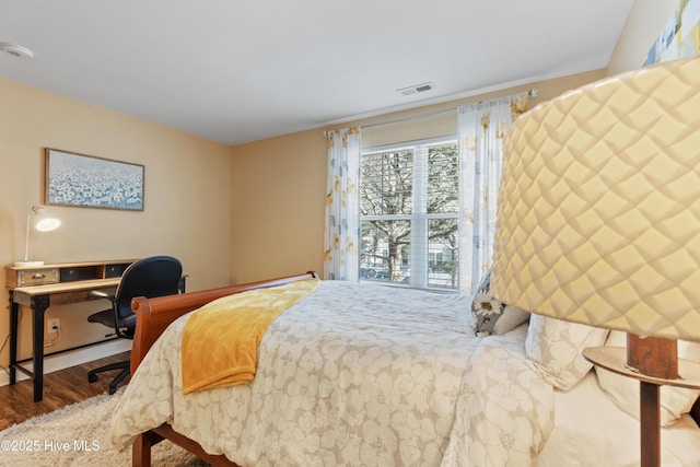 bedroom with wood finished floors and a desk