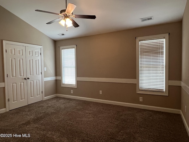 unfurnished bedroom featuring carpet flooring, lofted ceiling, a closet, and baseboards