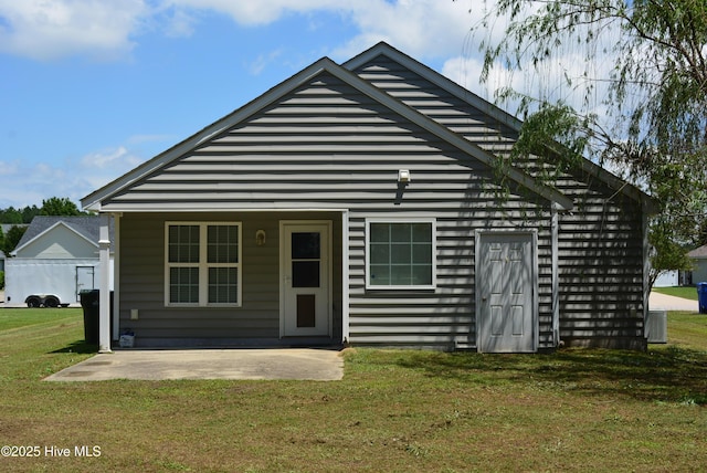 back of property with a yard and a patio area