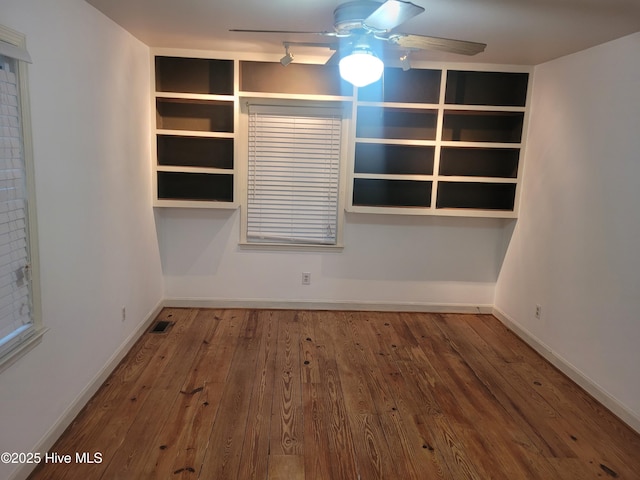 unfurnished room featuring a ceiling fan, wood finished floors, and baseboards