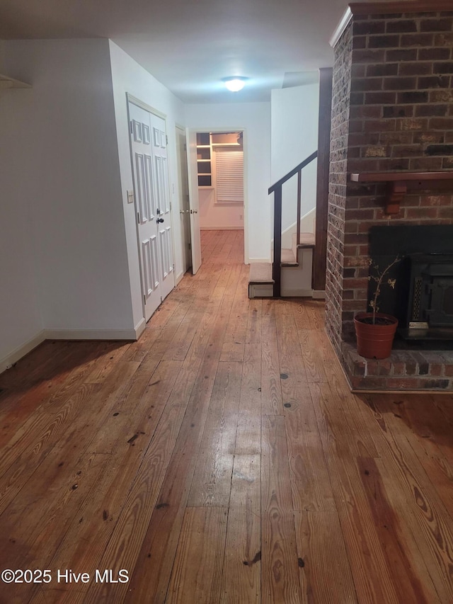 hallway featuring hardwood / wood-style floors, stairs, and baseboards