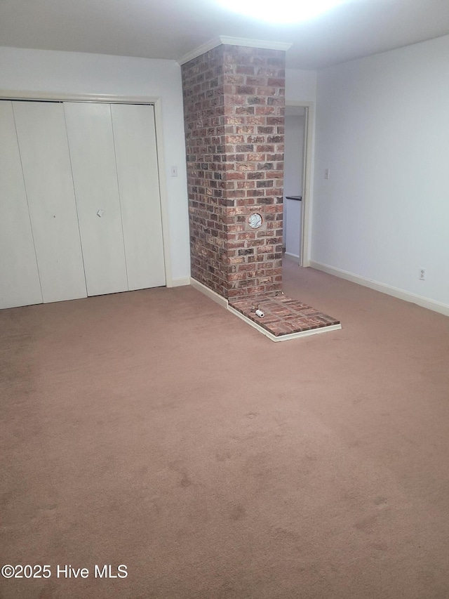 unfurnished living room with carpet and baseboards
