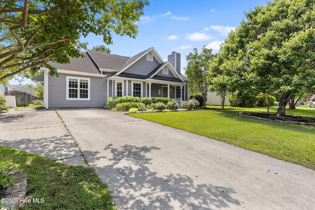 view of front of property with a front yard, a chimney, driveway, and a shingled roof