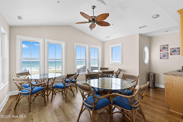 2112 Arnold Palmer Dr, Shallotte, NC 28470 - dining area featuring wood finished floors, ceiling fan, lofted ceiling, baseboards, and a water view