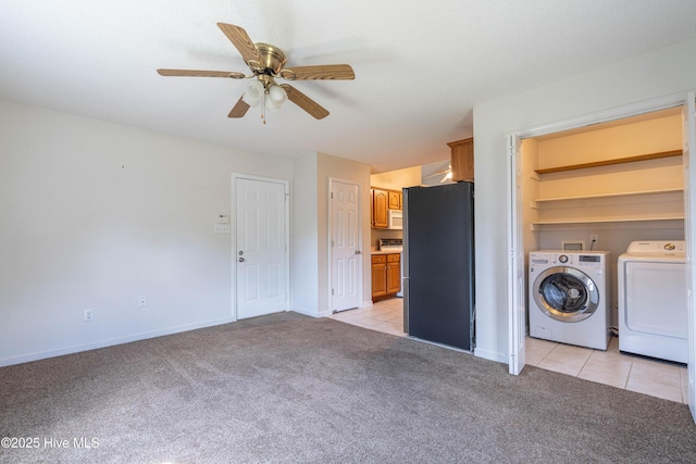 washroom featuring washer and dryer, light colored carpet, ceiling fan, and light tile patterned floors