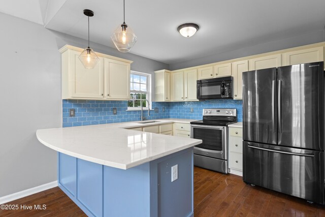 149 Lee St, Holly Ridge, NC 28445 - kitchen with stainless steel appliances, a sink, a peninsula, cream cabinets, and dark wood-type flooring