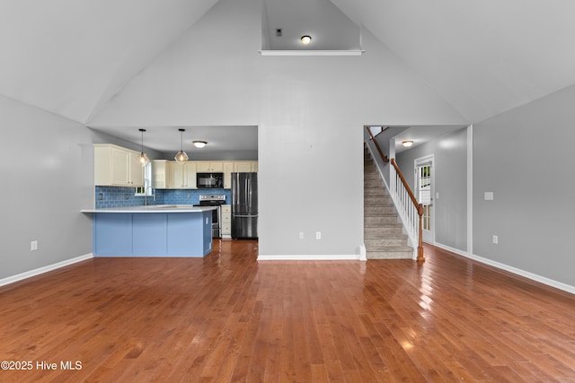 149 Lee St, Holly Ridge, NC 28445 - unfurnished living room with high vaulted ceiling, wood finished floors, stairs, and baseboards
