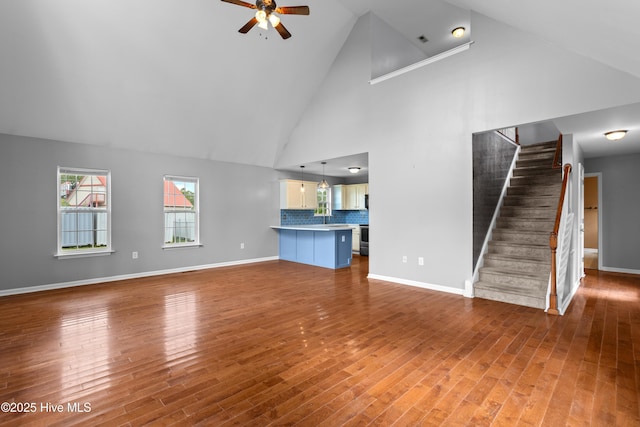 149 Lee St, Holly Ridge, NC 28445 - unfurnished living room with ceiling fan, high vaulted ceiling, stairs, wood finished floors, and baseboards