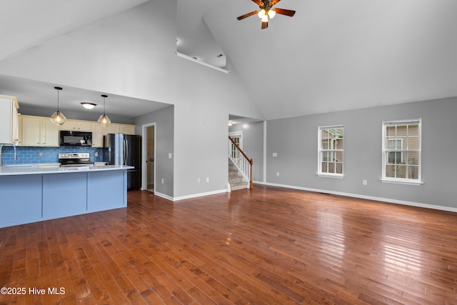 149 Lee St, Holly Ridge, NC 28445 - unfurnished living room featuring ceiling fan, stairs, high vaulted ceiling, dark wood-style floors, and baseboards