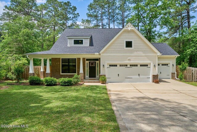 11 Bedford Cir, Pinehurst, NC 28374 - craftsman-style house featuring brick siding, driveway, an attached garage, and a shingled roof