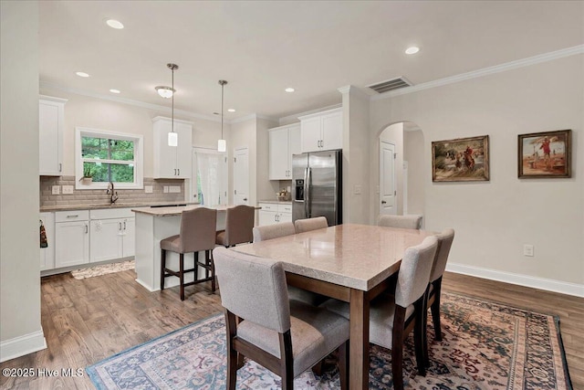 11 Bedford Cir, Pinehurst, NC 28374 - dining area featuring arched walkways, dark wood-type flooring, ornamental molding, baseboards, and recessed lighting