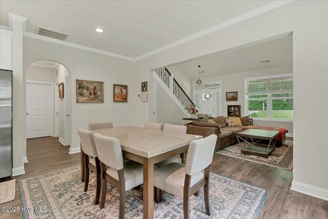 11 Bedford Cir, Pinehurst, NC 28374 - dining area with arched walkways, stairs, wood finished floors, ornamental molding, and baseboards