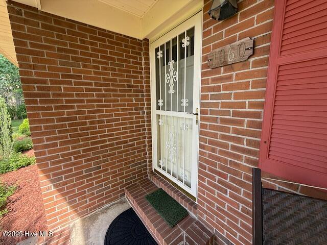 entrance to property featuring brick siding