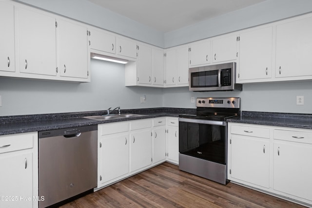 2414 Educational Dr, New Bern, NC 28562 - kitchen featuring stainless steel appliances, a sink, dark wood-type flooring, dark countertops, and white cabinetry