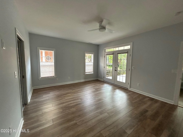 unfurnished room with healthy amount of natural light, ceiling fan, french doors, and dark wood-style floors