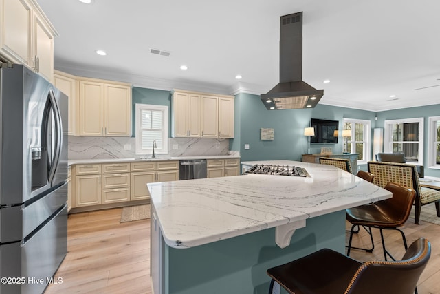 114 Lucas Cv, Oak Island, NC 28465 - kitchen with appliances with stainless steel finishes, cream cabinets, island range hood, ornamental molding, and a sink