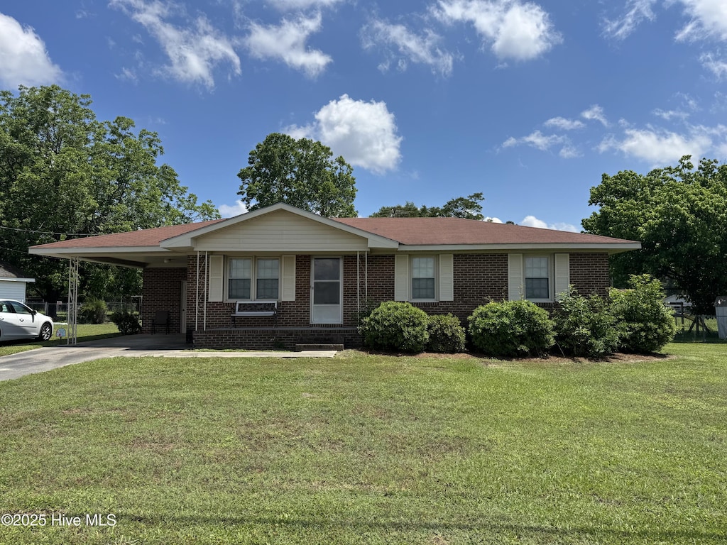 ranch-style house with concrete driveway, brick siding, a carport, and a front yard