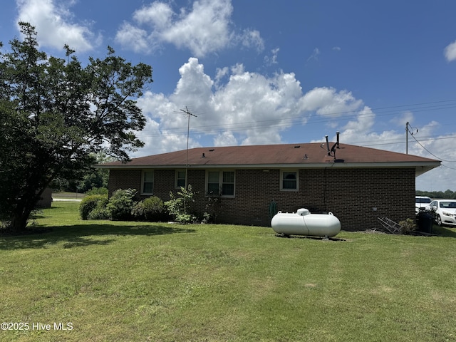 back of house with a lawn and brick siding