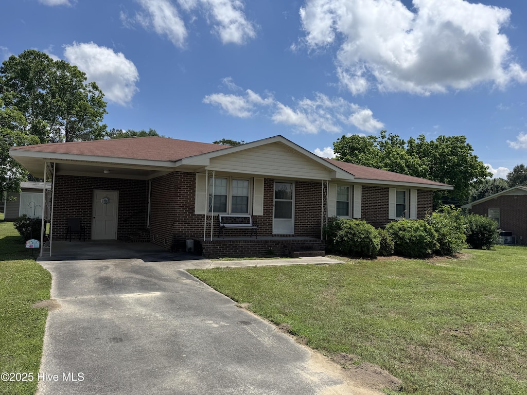 ranch-style house featuring driveway, brick siding, a front lawn, and a carport