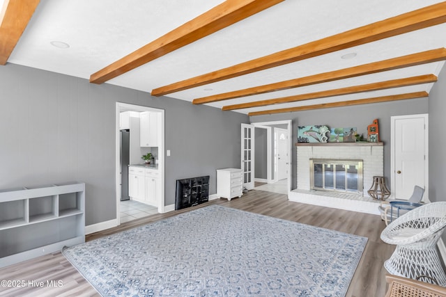 320 Embassy Cir, Wilmington, NC 28412 - living room featuring beamed ceiling, a fireplace, and light wood finished floors