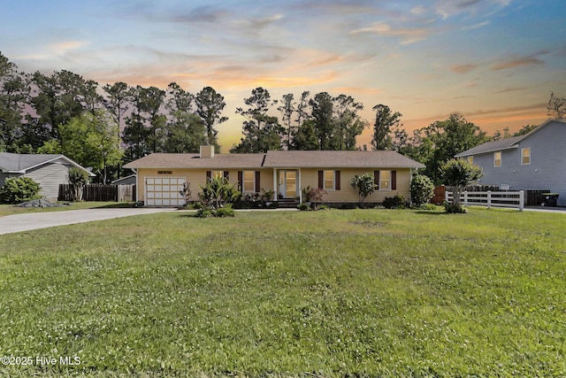 ranch-style house with an attached garage, concrete driveway, and a chimney