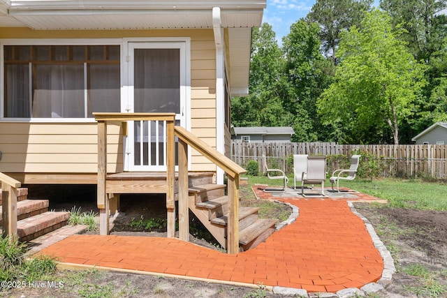 wooden deck with fence and a patio