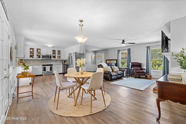 dining area with light wood finished floors and a ceiling fan