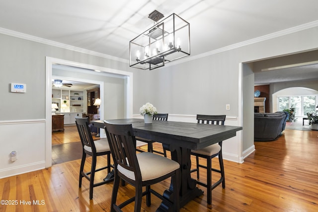 221 Quail Ridge Rd, Wilmington, NC 28409 - dining space with crown molding, light wood finished floors, arched walkways, and baseboards