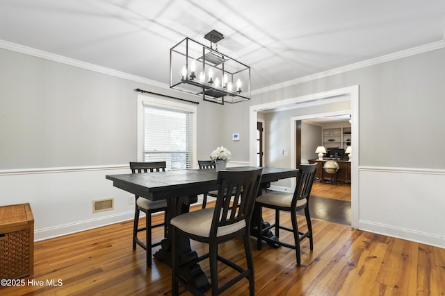 221 Quail Ridge Rd, Wilmington, NC 28409 - dining room featuring a chandelier, crown molding, hardwood / wood-style floors, and baseboards