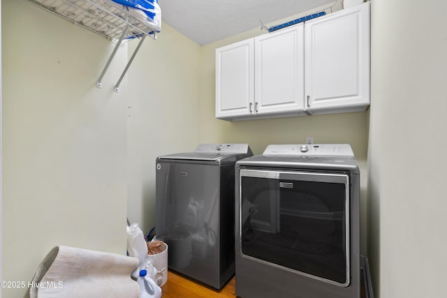 221 Quail Ridge Rd, Wilmington, NC 28409 - laundry area featuring washer and dryer, cabinet space, and light wood finished floors