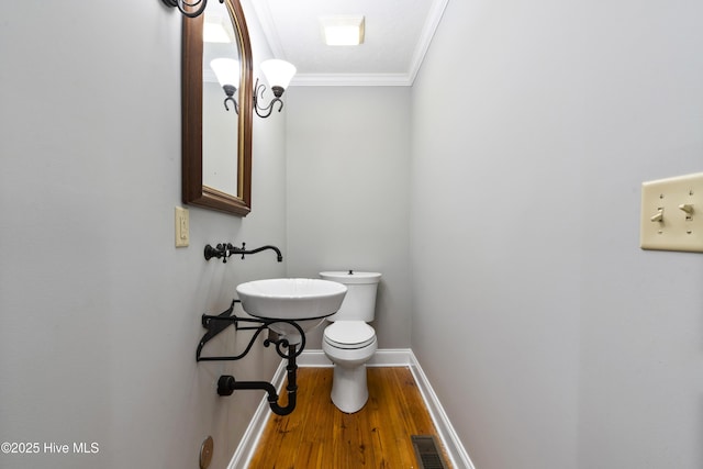 221 Quail Ridge Rd, Wilmington, NC 28409 - bathroom with a sink, ornamental molding, wood finished floors, toilet, and baseboards
