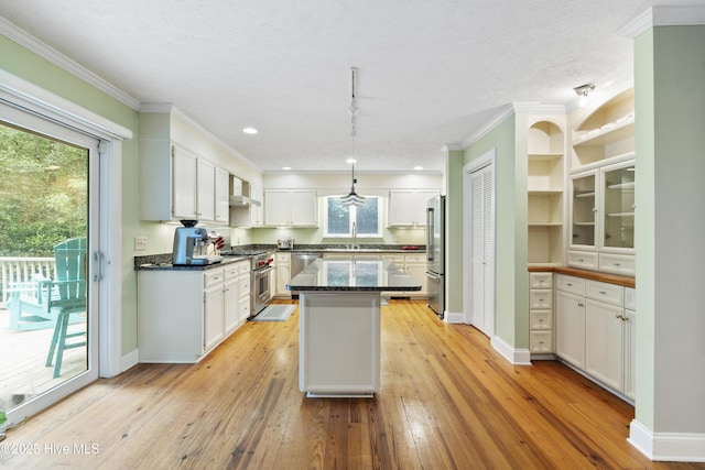 221 Quail Ridge Rd, Wilmington, NC 28409 - kitchen with high end appliances, wall chimney range hood, a center island, crown molding, and white cabinets